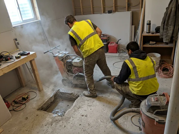 Dust-shrouded saw cut in a basement slab
